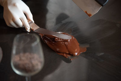 High angle view of hand holding ice cream on table