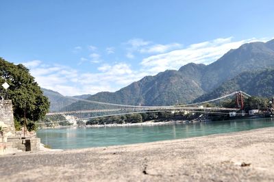 Bridge over river against cloudy sky