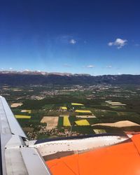 Airplane flying over field against sky