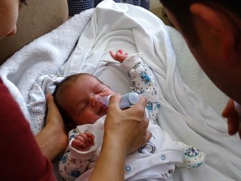 Cropped image of parents with newborn at home