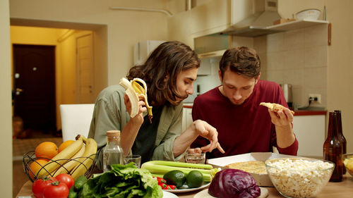 Gay couple preparing food at home