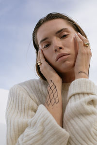 Portrait of young woman against sky