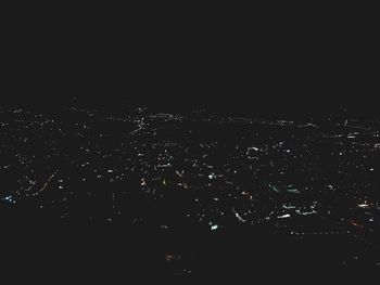 High angle view of illuminated city against clear sky at night