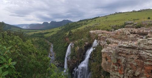 Scenic view of waterfall against sky