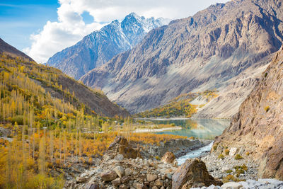 Scenic view of lake by mountains against sky