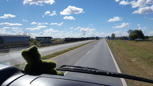 Low section of man on road against sky