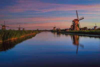 Panoramic view of traditional windmill against sky during sunset