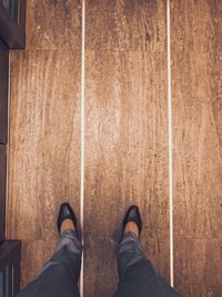 Low section of woman standing on hardwood floor