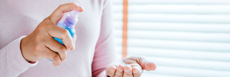 Cropped hand of woman applying nail polish