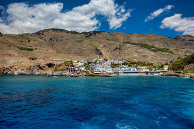 Scenic view of sea and mountains against sky