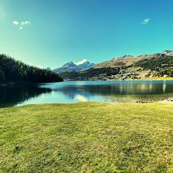 Scenic view of lake by mountains against sky