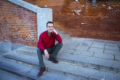 Portrait of young man standing against wall