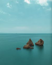 Rocks in sea against sky