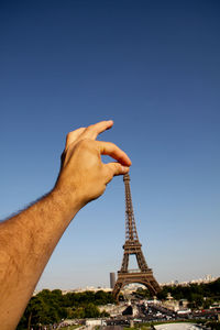 Low angle view of woman tower against clear blue sky