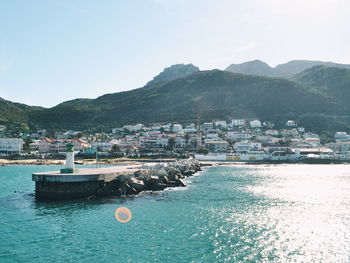 Boats in sea with city in background