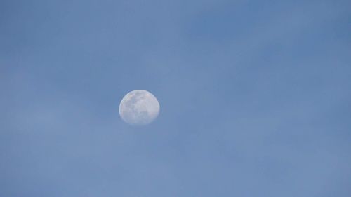 Low angle view of moon against blue sky