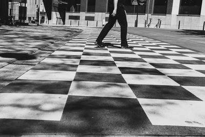 Low section of man walking on tiled floor