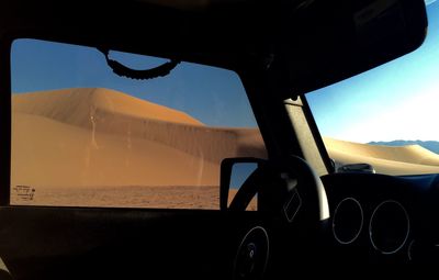 Close-up of car on landscape against sky