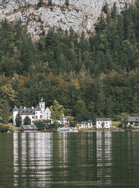 Scenic view of lake by buildings against trees