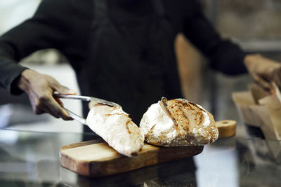 Salesman packing fresh bread while working at bakery