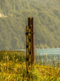 Information sign on field against sky