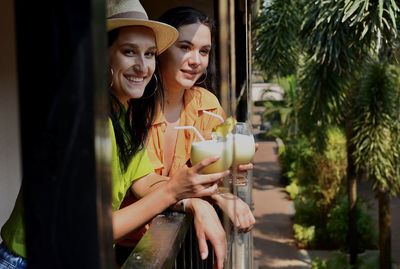 Portrait of smiling young woman holding drink