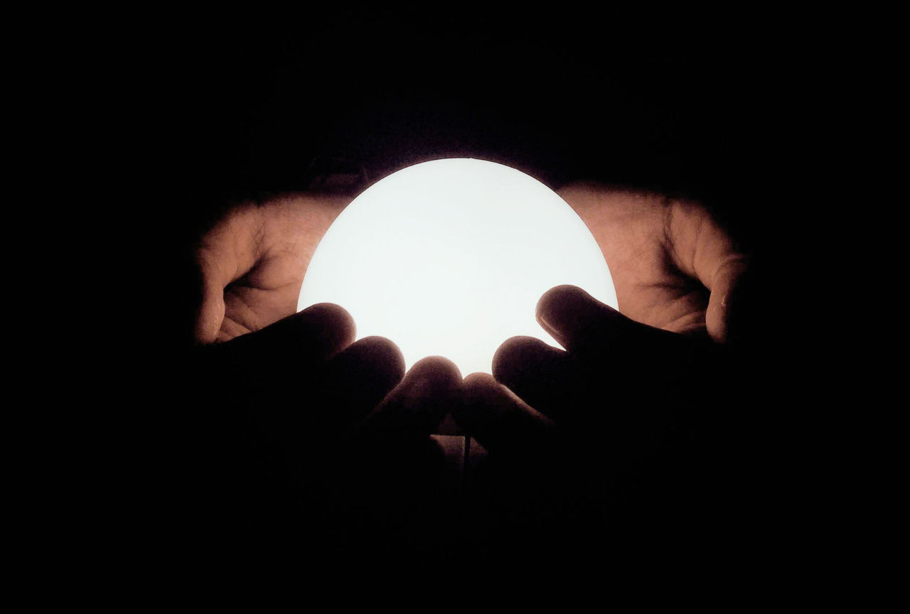 CLOSE-UP OF HAND HOLDING LIGHT PAINTING