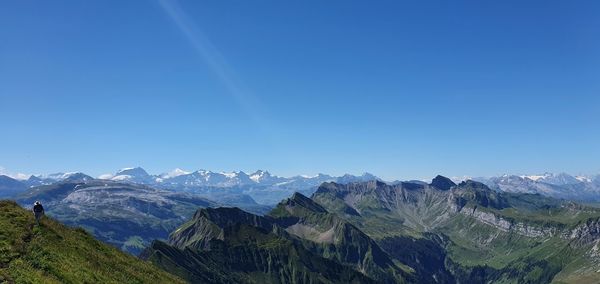 Panoramic view of snowcapped mountains against clear blue sky