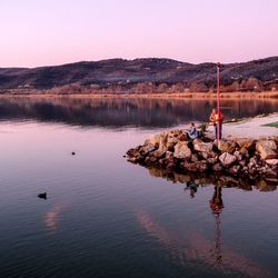 Scenic view of lake against clear sky during sunset