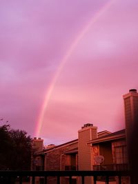 Low angle view of rainbow over buildings in city