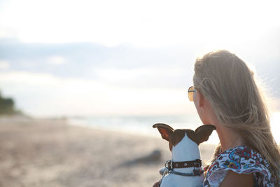 Side view of woman with dog at beach