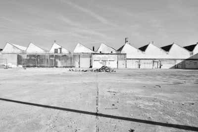 Houses on beach by buildings against sky