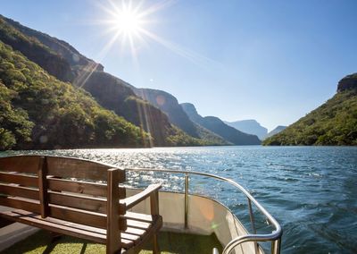 Scenic view of lake by mountains against blue sky