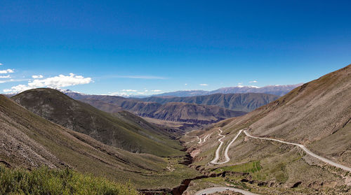 Scenic view of mountains against blue sky