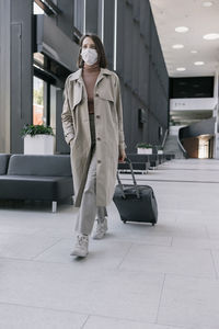 Full length of young woman standing in city