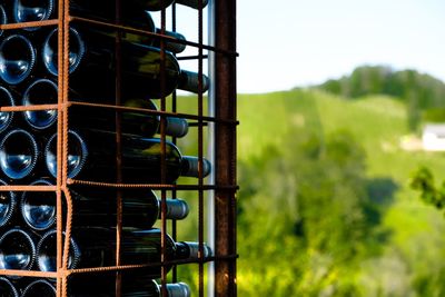 Close-up of metal fence on field against sky