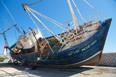 Abandoned boat moored in sea against clear sky