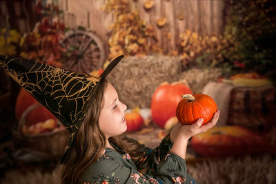 Portrait of young woman holding pumpkin