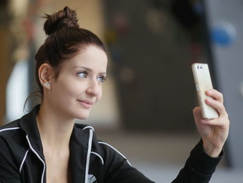 Close-up portrait of young woman using mobile phone