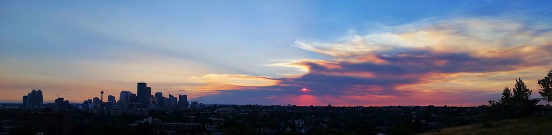 View of cityscape against cloudy sky during sunset