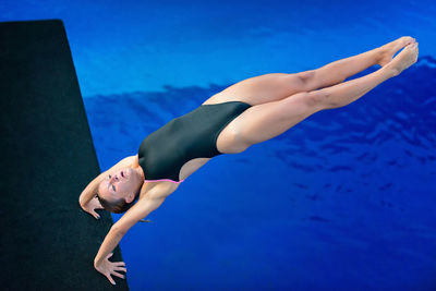 High angle view of woman diving into swimming pool