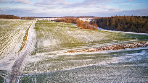 Winter agricultural field snow. aerial scene. december rural landscape. countryside road top view