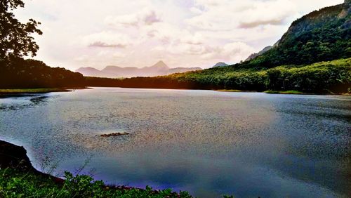 Scenic view of lake by mountains against sky