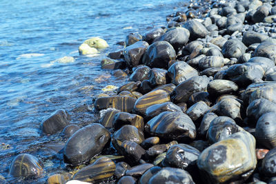 Closeup group of wet polished stones and pebbles were surfed by the sea