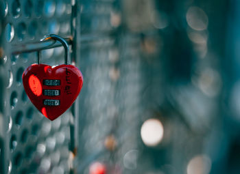 Close-up of heart shape padlock hanging on metal