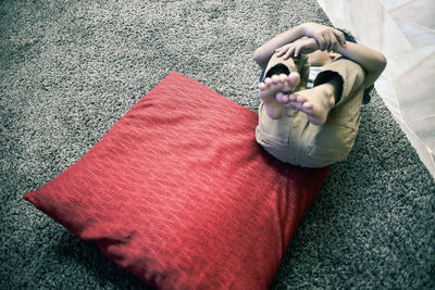 High angle view of boy relaxing on rug at home