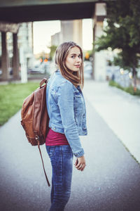 Portrait of woman standing on road in city