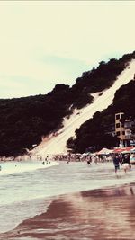 Group of people on beach against sky