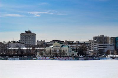 Buildings in city against sky during winter