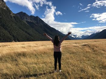 Full length of woman standing on field against sky